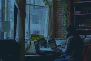 Woman working on laptop in a café.