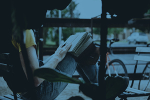 Student reading sitting in a comfortable chair outdoors.