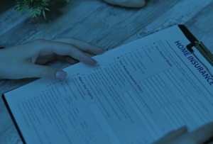 Home Insurance paperwork on a clipboard with hands